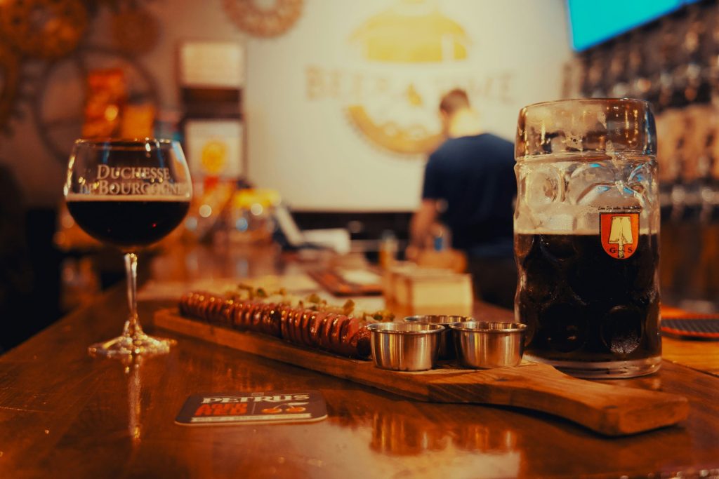 A wooden table topped with two glasses of beer